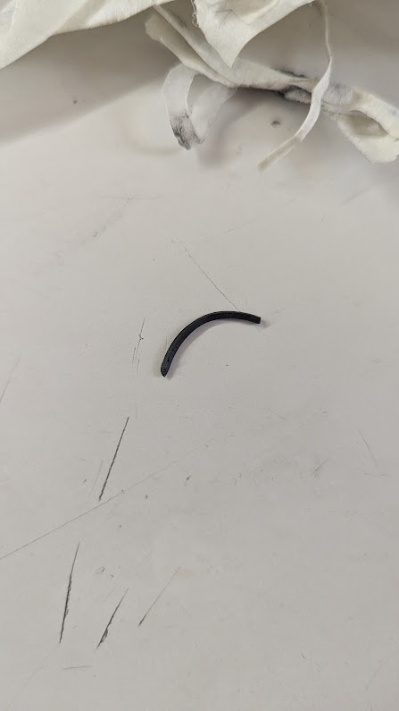 A picture of a piece of rubber that's not a whole circle but only a part of one.